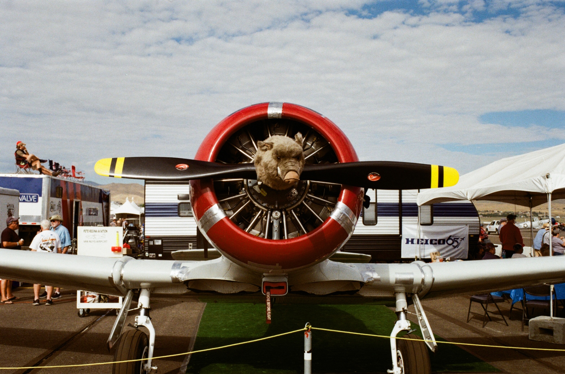 Radial engine warbird with red cowling head-on at an airshow