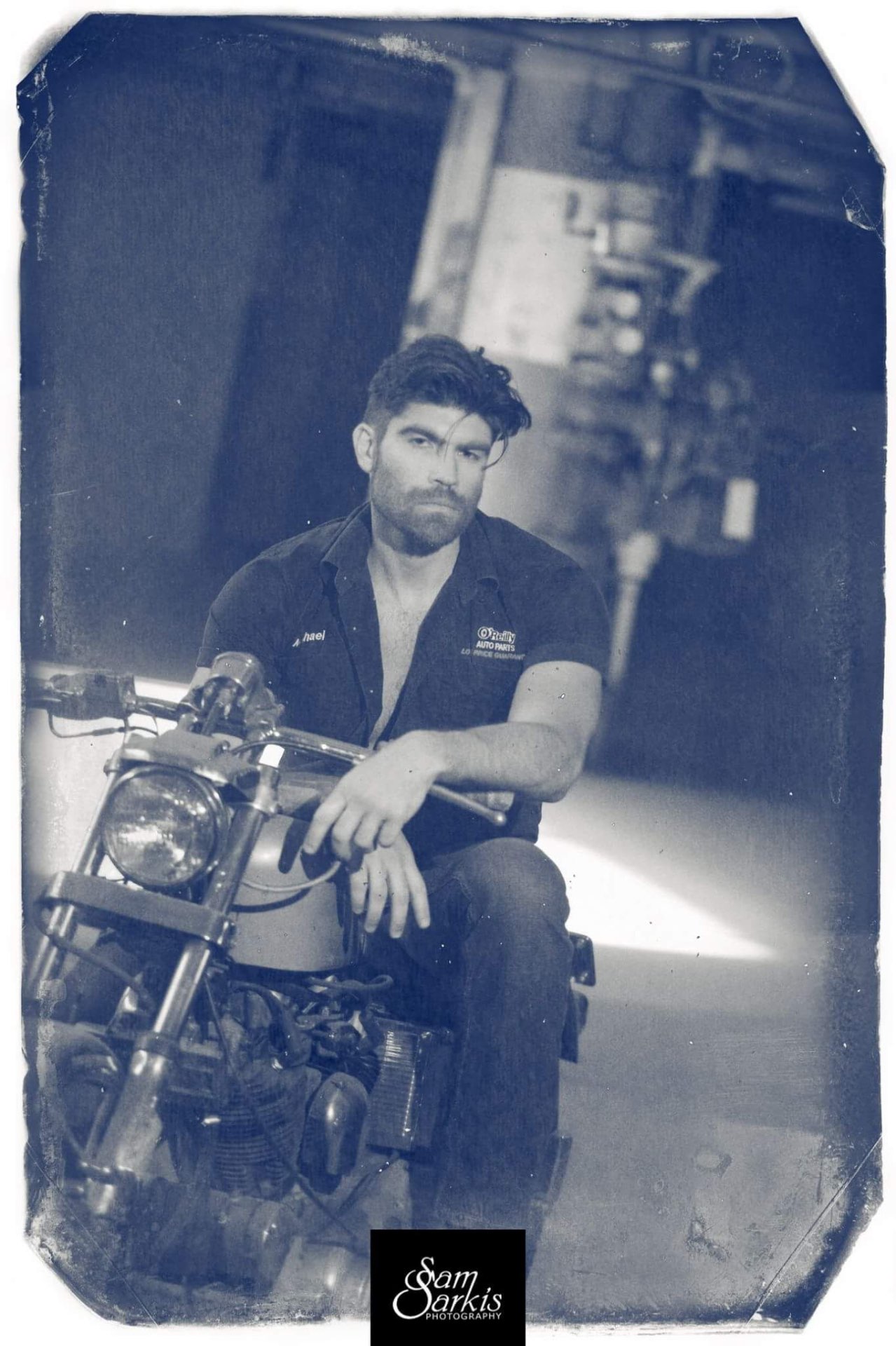 Tintype-style portrait of Michael Boryca Jr on a vintage motorcycle in a shop
